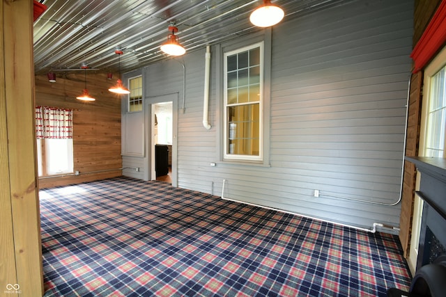 unfurnished living room with a fireplace and wood walls