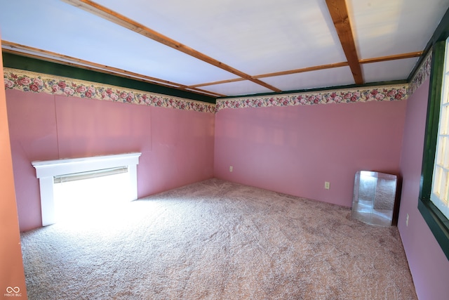 carpeted empty room featuring beam ceiling