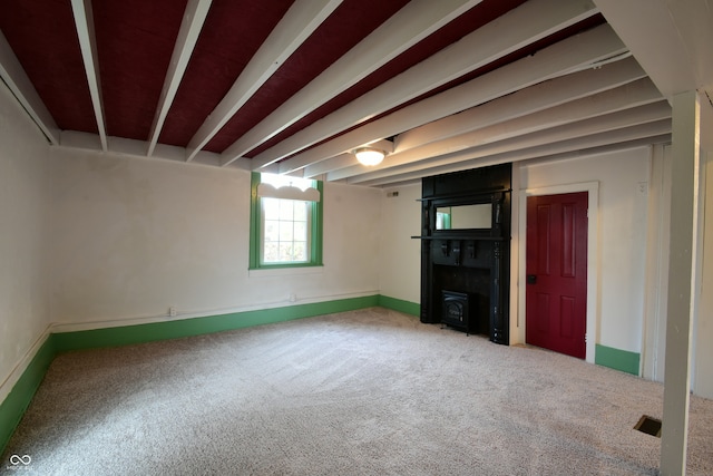 unfurnished living room with carpet floors and a wood stove