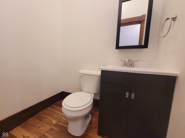 bathroom with vanity, toilet, and wood-type flooring