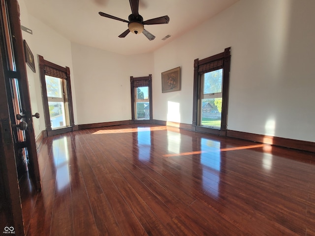 empty room with ceiling fan and dark hardwood / wood-style flooring