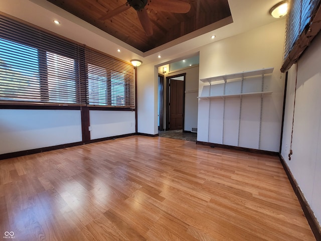 unfurnished room featuring light hardwood / wood-style floors, a raised ceiling, and ceiling fan