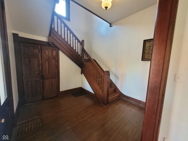 entrance foyer featuring vaulted ceiling and dark hardwood / wood-style floors