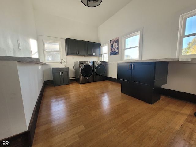 washroom featuring washer and dryer, cabinets, and a wealth of natural light