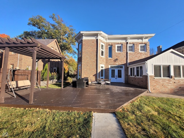 back of property featuring a wooden deck and a pergola