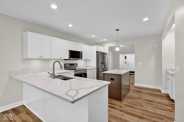 kitchen with kitchen peninsula, stainless steel appliances, and hanging light fixtures