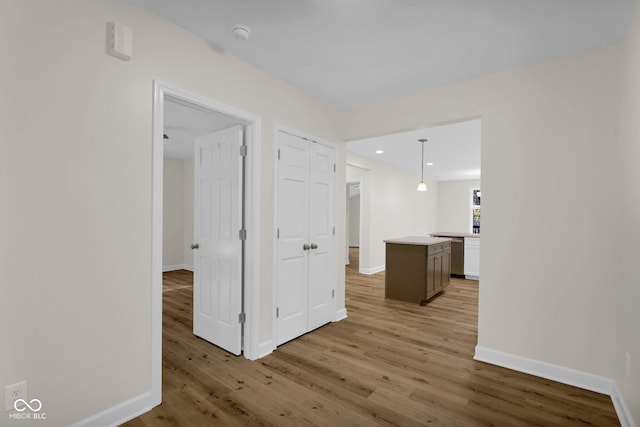 hallway with light hardwood / wood-style floors