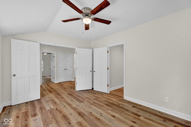 unfurnished bedroom with lofted ceiling, light wood-type flooring, and ceiling fan