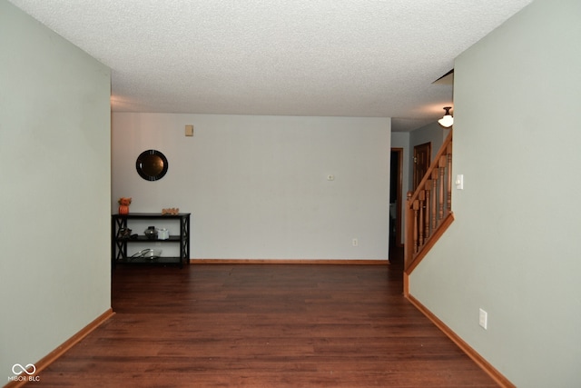 interior space with a textured ceiling and dark wood-type flooring