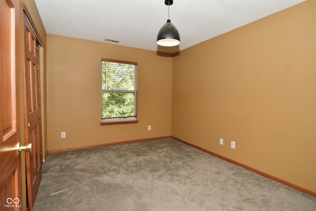 carpeted spare room with a textured ceiling