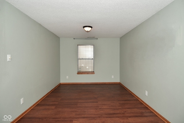 unfurnished room featuring a textured ceiling and dark hardwood / wood-style flooring