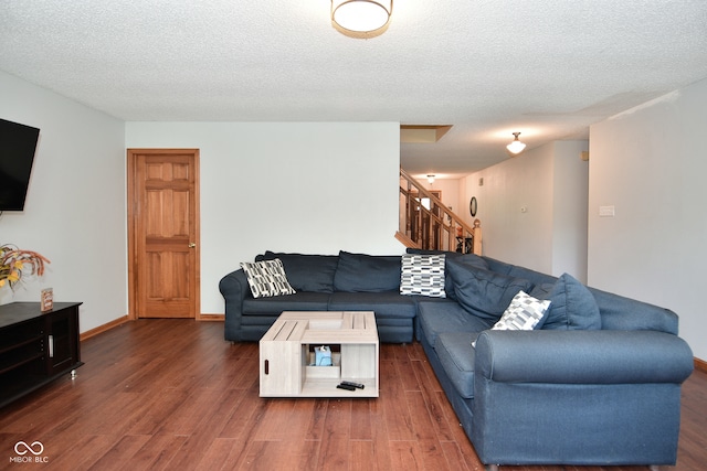 living room featuring a textured ceiling and dark hardwood / wood-style floors