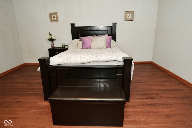 bedroom with dark hardwood / wood-style flooring