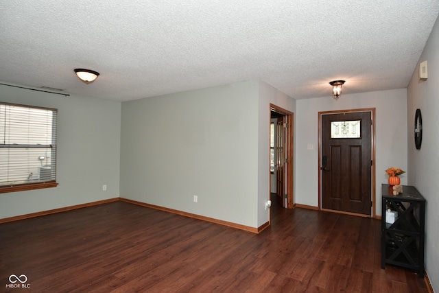 foyer entrance with dark wood-type flooring and a textured ceiling