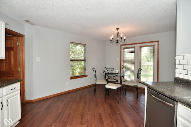 unfurnished dining area featuring dark hardwood / wood-style floors, a chandelier, and a textured ceiling