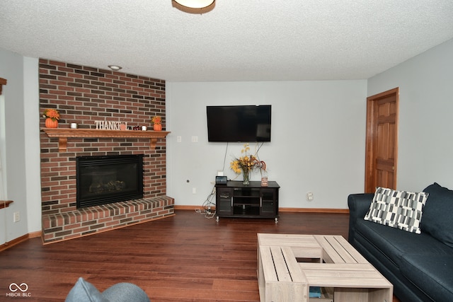 living room with a textured ceiling, dark wood-type flooring, and a fireplace