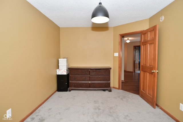 bedroom featuring a textured ceiling and light colored carpet