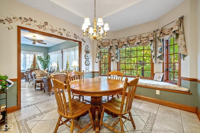 tiled dining area with a wealth of natural light and ceiling fan with notable chandelier