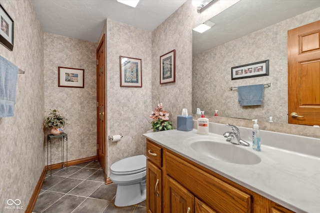 bathroom featuring toilet, a textured ceiling, vanity, and tile patterned floors