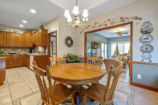 dining area featuring sink, ceiling fan with notable chandelier, and light tile patterned floors