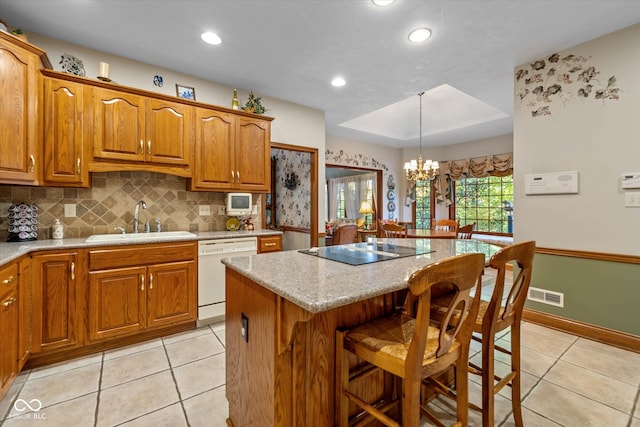 kitchen featuring a kitchen island, black electric cooktop, dishwasher, decorative light fixtures, and sink