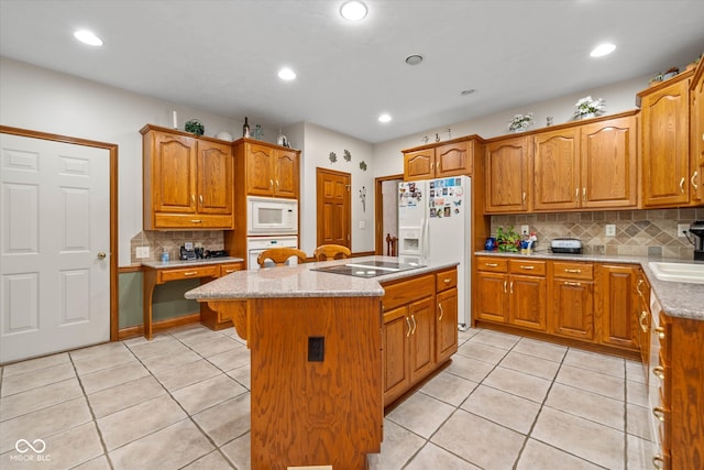 kitchen featuring backsplash, sink, a center island, light tile patterned flooring, and white appliances