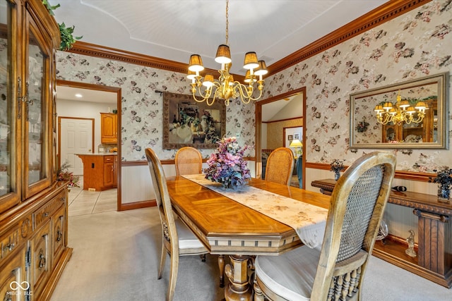 carpeted dining area featuring ornamental molding and an inviting chandelier