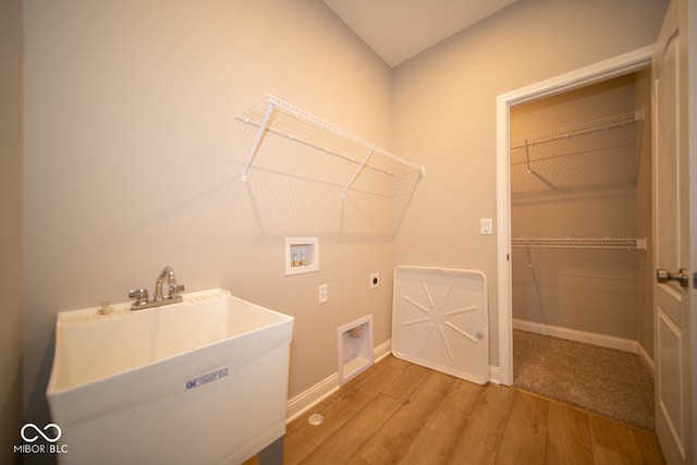 clothes washing area with washer hookup, electric dryer hookup, sink, and hardwood / wood-style flooring