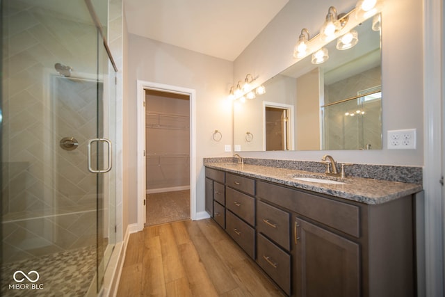 bathroom featuring vanity, an enclosed shower, and wood-type flooring