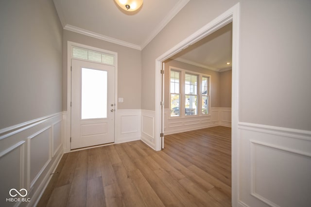 foyer entrance with light hardwood / wood-style floors and ornamental molding