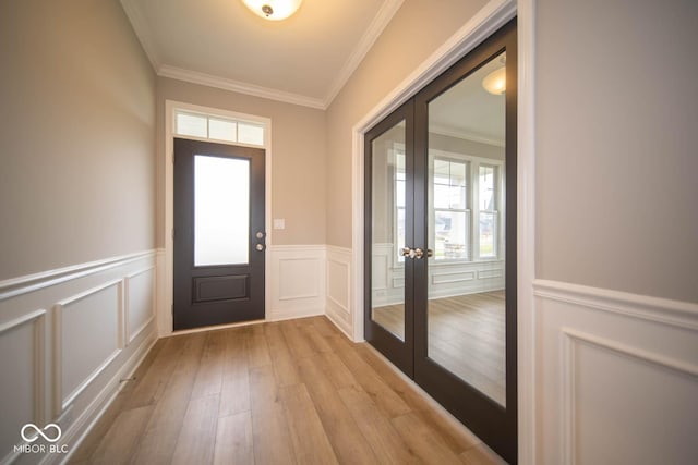 entryway featuring crown molding, plenty of natural light, light hardwood / wood-style floors, and french doors