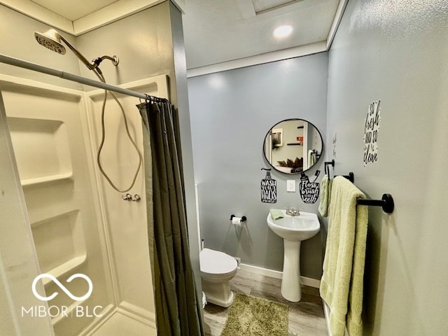 bathroom featuring toilet, walk in shower, and hardwood / wood-style flooring