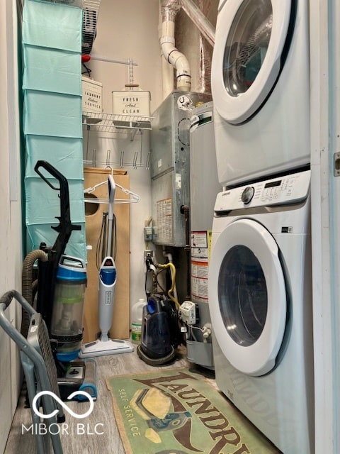 laundry area with gas water heater and stacked washer / drying machine