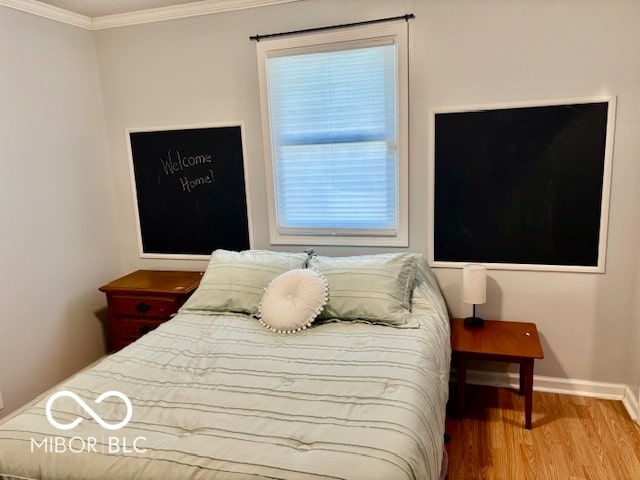 bedroom featuring wood-type flooring and ornamental molding