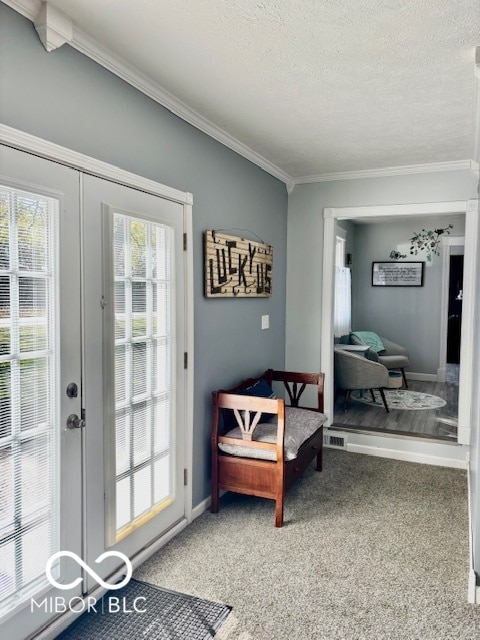 doorway to outside featuring french doors, a textured ceiling, carpet flooring, and crown molding