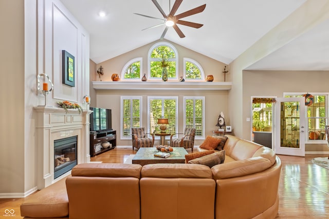 living room with light hardwood / wood-style floors, high vaulted ceiling, and ceiling fan