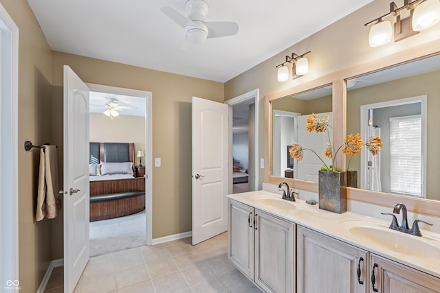 ensuite bathroom featuring double vanity, ensuite bath, a ceiling fan, and a sink