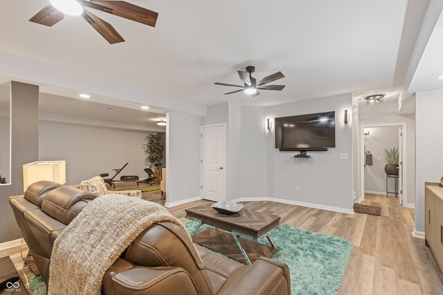 living room with light hardwood / wood-style flooring and ceiling fan