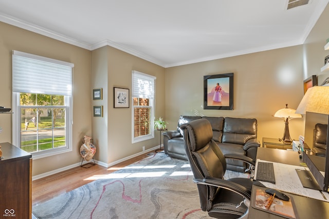 office with light hardwood / wood-style floors and ornamental molding