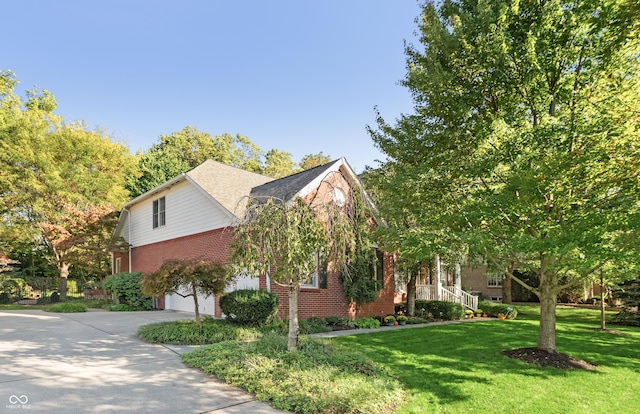 view of front of property with a garage, a front lawn, brick siding, and concrete driveway