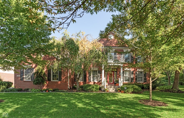 view of front of home featuring a balcony and a front lawn