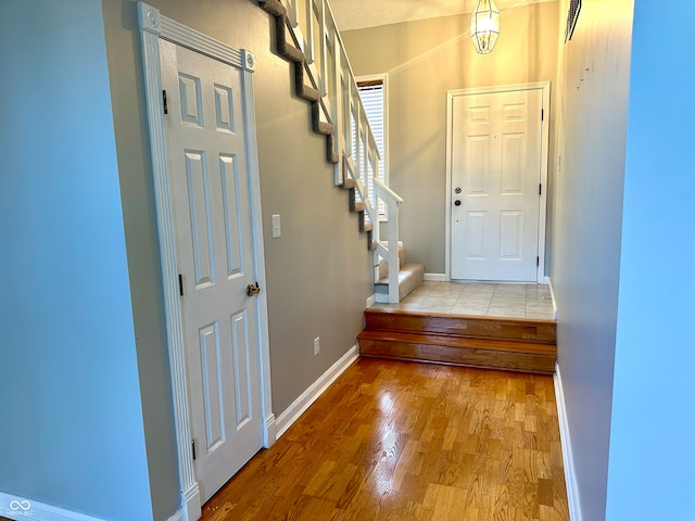 entrance foyer with light hardwood / wood-style flooring and a textured ceiling