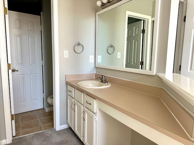 bathroom with tile patterned flooring, vanity, and toilet