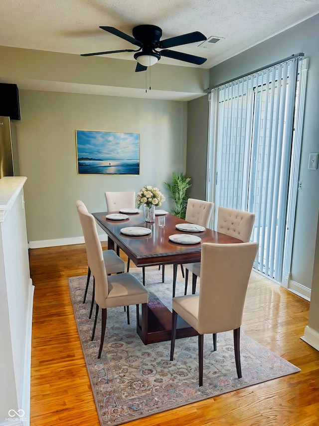 dining room featuring hardwood / wood-style floors, a wealth of natural light, and ceiling fan