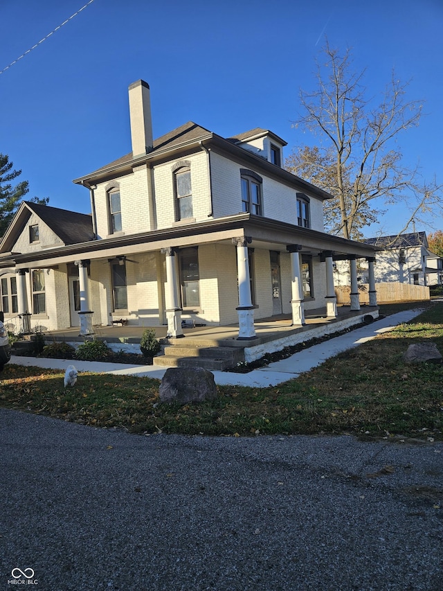 201 W Walnut St, Waldron, IN 46182 - view of front of home with brick siding, covered porch, and a chimney