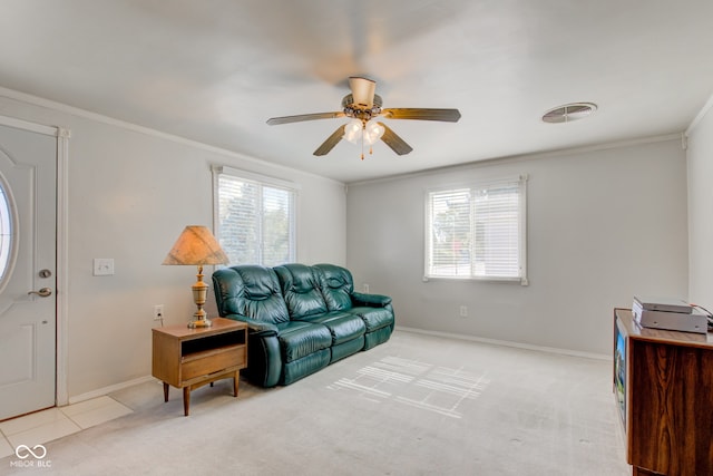 living room with ceiling fan, ornamental molding, a wealth of natural light, and light colored carpet