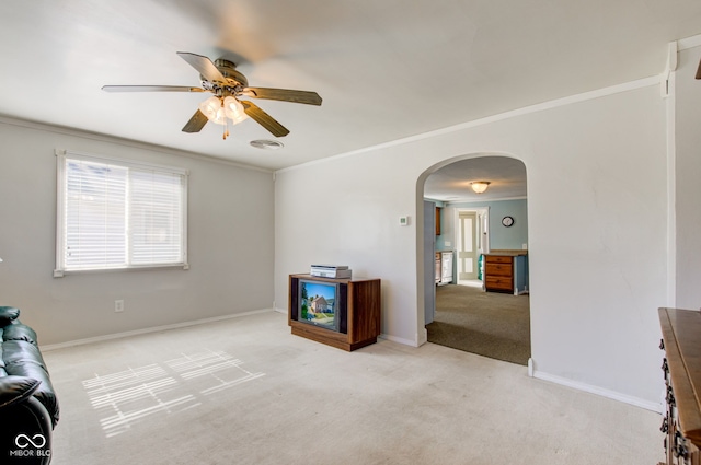 interior space with crown molding, light colored carpet, and ceiling fan