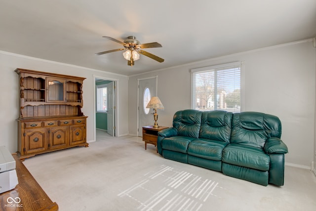 carpeted living room with ceiling fan, a healthy amount of sunlight, and ornamental molding