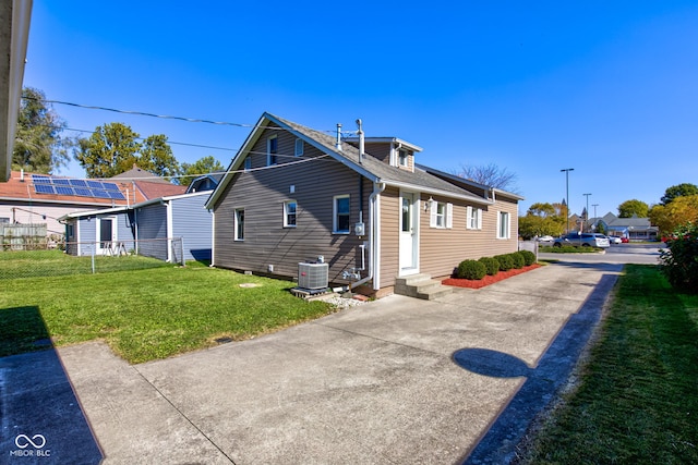 back of house featuring a yard and central AC unit