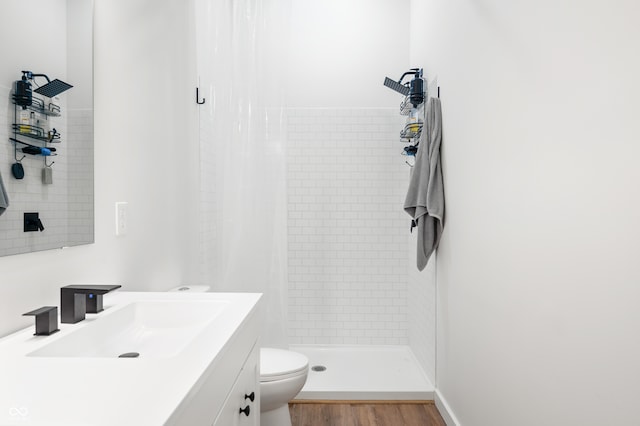 bathroom featuring vanity, hardwood / wood-style floors, a shower with shower curtain, and toilet